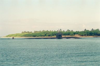 The nuclear-powered attack submarine USS HONOLULU (SSN-718) moves through the channel as it arrives for a visit to the naval station.