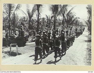 JACQUINOT BAY, NEW BRITAIN. 1945-04-21. BRIGADIER C.R.V. EDGAR, COMMANDER 4 INFANTRY BRIGADE (1), TAKES THE SALUTE FROM C COMPANY, 37/52 INFANTRY BATTALION DURING THE MARCH PAST