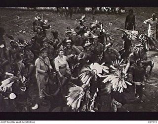 DOBODURA, NEW GUINEA. 1943-10-10. NATIVE DANCERS DANCING AROUND ALLIED SERVICEMEN AND NURSES DURING A CEREMONIAL DANCE
