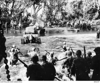 CAPE GLOUCESTER, NEW BRITAIN. 1943-12. US MARINES, ARMED WITH M1 CARBINES, M1 GARND RIFLES AND THOMPSON SUB MACHINE GUNS, WADE ASHORE FROM A LANDING SHIP, TANK (LST) DURING THE INVASION. A ..