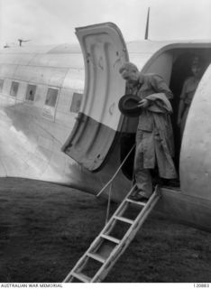 RABAUL, NEW BRITAIN. 1945-12-28. THE PRIME MINISTER OF AUSTRALIA, MR BEN CHIFLEY, ARRIVED BY PLANE TO VISIT MANY OF THE UNITS IN THE AREA. MR CHIFLEY DESCENDS FROM HIS RAAF DOUGLAS C47 DAKOTA AT ..