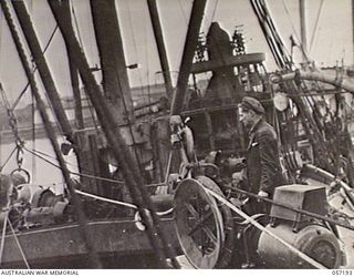 MELBOURNE, VIC. 1943-09-01. CABLE HAULING WINCH FEEDING CABLE INTO THE HOLD OF THE SS. MERNOO, MARINE CABLE LAYING SHIP, IN PREPARATION FOR LAYING THE CABLE FROM CAPE YORK, NORTH QUEENSLAND TO PORT ..