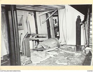 OFF PORT MORESBY, PAPUA. 1942-08-30. THE DAMAGED ENTRANCE TO THE LOUNGE OF M.V. MALAITA SUSTAINED WHEN THE SHIP WAS TORPEDOED BY AN ENEMY SUBMARINE OFF PORT MORESBY. THE TORPEDO ENTERED THE VESSEL ..