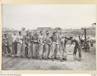 CAPE WOM, WEWAK AREA, NEW GUINEA. 1945-10-13. MEMBERS OF C COMPANY, 2/1 GUARD REGIMENT, QUEUEING UP FOR THEIR MORNING MUG OF TEA