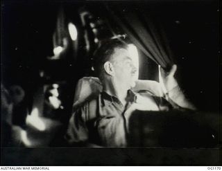 IN FLIGHT BETWEEN HOLLANDIA, DUTCH NEW GUINEA AND AITAPE, NORTH EAST NEW GUINEA. C. 1944-06. JOHN DEDMAN, THE MINISTER FOR WAR ORGANISATION OF INDUSTRY, LOOKING THROUGH THE AIRCRAFT WINDOW, ..