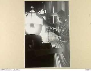 ALEXISHAFEN, NEW GUINEA. 1944-05-15. NX15966 STAFF SERGEANT B. R. EATON, 2/15TH FIELD AMBULANCE (1), MAKES USE OF ABANDONED JAPANESE EQUIPMENT TO FILTER STERILE WATER. THE DISPENSARY IS LOCATED AT ..