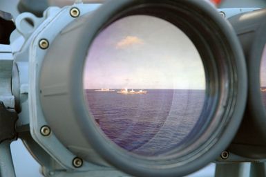 Onboard the US Navy (USN) Ticonderoga Class Guided Missile Cruiser (Aegis) USS COWPENS (CG 63), reflected in the "Big Eyes" are the Russian Federation Navy Dubna Class, Replenishment Tanker, PECHENGA and the USN Guided Missile Cruiser (Aegis) USS CHOSIN (CG 65), underway in the Pacific Ocean, during the opening phases of a joint US-Russian Naval Exercise. A Russian Federation Navy vessel made the first visit to the US Territory of Guam in order to participate in a joint humanitarian assistance and disaster relief exercise