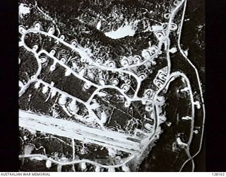 PORT MORESBY, NEW GUINEA. 1943-04-03. WARD'S FIELD, SHOWING THE EXTENSIVE DEVELOPMENT OF THE BASE AND DISPERSED LIBERATOR BOMBERS AND DOUGLAS TRANSPORT AIRCRAFT. THE STAGGERED AND CURVED LINES OF ..