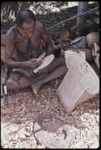 Carving: M'lapokala cuts design into a canoe prowboard, carved splashboard (r)