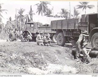 MADANG, NEW GUINEA. 1944-08-15. PERSONNEL OF B COMPANY, 165TH GENERAL TRANSPORT COMPANY CHECKING AND GREASING VEHICLES ON THE UNIT COCONUT LOG RAMPS