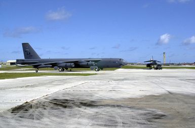 A US Air Force (USAF) B-1B Lancer, 7th Bomb Wing (BW), Dyess Air Force Base (AFB), Texas (TX), parked as a B-52H Stratofortress, 2nd BW, Barksdale AFB, Louisiana (LA), taxis out for take off on Andersen (AFB), Guam. The bombers are here supporting the 7th Air Expeditionary Wing's (AEW) mission