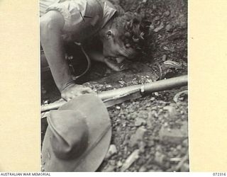 YAULA, NEW GUINEA. 1944-04-12. QX58967 SIGNALMAN W.S. NEANDER, 57/60TH INFANTRY BATTALION, DRINKING FROM A MOUNTAIN SPRING DURING THE ADVANCE TO BAGADJIM