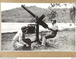 GODOWA, NEW GUINEA. 1943-11-05. PRIVATE FIRST CLASS R. J. HOARD (PRC) OF JAMESTOWN, USA, (LEFT) AND PRIVATE FIRST CLASS S. A. BROSTEK OF PHOENIX, USA, (RIGHT) BOTH OF THE UNITED STATES 102ND COAST ..