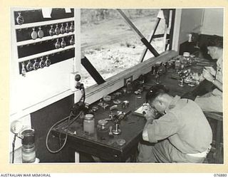 LAE AREA, NEW GUINEA. 1944-11-15. NX163489 CRAFTSMAN S. JONES (1) AND QX50160 CRAFTSMAN R.J. BRADLEY (2) WATCHMAKERS, 2/7TH ADVANCED WORKSHOPS WORKING IN THE UNIT INSTRUMENT REPAIR SECTION