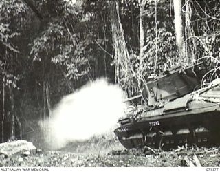 KILIGIA, NEW GUINEA. 1944-03-16. A MATILDA TANK OF A SQUADRON, 1ST TANK BATTALION, FIRING ITS TWO-POUNDER GUN AT JAPANESE FOX-HOLES IN THE REENACTMENT OF AN EARLIER SCENE
