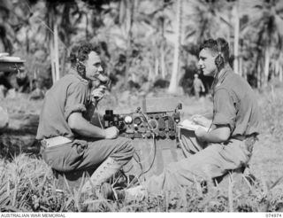 MILILAT, NEW GUINEA. 1944-07-26. VX117892 GUNNER J.H. TYRRELL (1) AND NX192462 GUNNER J. MINITER (2) "F" TROOP, 64TH BATTERY, 2/14TH FIELD REGIMENT, OPERATING AN AIR TO GROUND RADIO DURING A ..