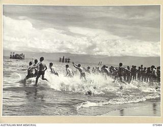 LAE, NEW GUINEA. 1944-08-27. COMPETITORS ENTERING THE WATER AT THE START OF THE SURF RACE DURING THE SURF CARNIVAL ORGANISED BY HQ, 5TH DIVISION ON MALAHANG BEACH