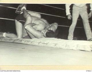 LAE, NEW GUINEA. 1944-07-22. A WRESTLING MATCH IN PROGRESS DURING THE BOXING TOURNAMENT STAGED BETWEEN AUSTRALIAN AND AMERICAN SERVICEMEN. IDENTIFIED PERSONNEL IS:- CORPORAL JOHN DECIECIO (UNITED ..