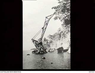 Rabaul, New Britain. 1949-09. A large floating crane which was sunk by Japanese bombers in early 1942. It had been towed pre-war from Singapore and is seen here lying half under water in the ..