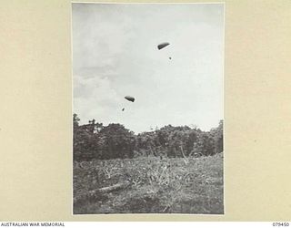 BARARA, BOUGAINVILLE ISLAND. 1945-03-07. PARACHUTES CARRYING FRESH MEAT FOR THE TROOPS OF THE 25TH INFANTRY BATTALION FLOATING DOWN ON THE DROPPING AREA AFTER BEING DROPPED FROM A RAAF DOUGLAS C47 ..