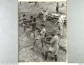 1943-06-15. NEW GUINEA. NATIVES AT A RIFLE RANGE AT A PAPUAN INFANTRY UNIT CAMP PRACTISE WITH AUTOMATIC OWEN GUN. (NEGATIVE BY N. BROWN)