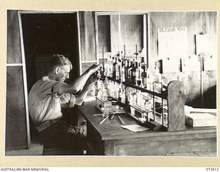 LAE, NEW GUINEA. 1944-05-24. VX72483 CORPORAL C.F. MACDONALD (1), MAKING CHEMICAL TESTS IN THE PATHOLOGY LABORATORY AT THE 2/7TH GENERAL HOSPITAL