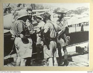 Port Moresby, New Guinea. 1942-04-12. Lieutenant Colonel E. T. Brennan, DSO, MC, Assistant Director of Medical Services, 8th Military District (left) talking with survivors of the Rabaul Garrison ..