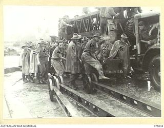 LAE, NEW GUINEA. 1944-08-09. TROOPS OF THE 20TH FIELD COMPANY, CARRYING A BOX GIRDER TO THE WATERS EDGE WHILE BUILDING THE BRIDGE ACROSS THE BUTIBUM RIVER TO REPLACE THE ONE WHICH WAS WASHED AWAY ..