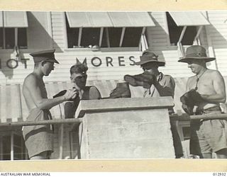 THE CARE AND APPEARANCE OF THEIR FOOTWEAR IS A RITUAL WITH THE A.I.F. ON ACTIVE SERVICE. PRIVATES J.H. REYNOLDS, N.S. LOCKHART, N.G. HAWKINS AND P.J. FILAN CLEANING THEIR BOOTS OUTSIDE THE HOTEL ..