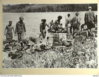 BIAMU, ORO BAY, NEW GUINEA. 1942-11-11. UNITED STATES STORES AND EQUIPMENT BEING UNLOADED FROM NATIVE CANOES AT BIAMU VILLAGE