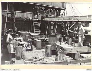 RABAUL, NEW BRITAIN. 1945-09-30. MEMBERS OF COMMONWEALTH SALVAGE BOARD FROM THE SALVAGE SHIP CAMBRIAN SALVOR EXAMINE CHOCKS ON THE FOREDECK OF THE JAPANESE TANKER NO. 5301 BELIEVED TO BE CRADLES ..