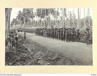 MADANG, NEW GUINEA. 1944-07-03. TROOPS OF C COMPANY, 24TH INFANTRY BATTALION GIVE "EYES RIGHT" FOR THEIR COMMANDING OFFICER, VX185, LIEUTENANT COLONEL G.F. SMITH, DSO (1) AS THEY MARCH ALONG THE ..