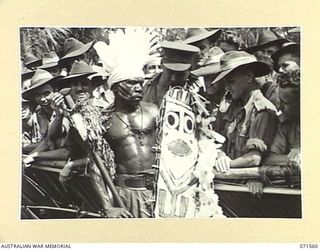 SONG RIVER, FINSCHHAFEN AREA, NEW GUINEA. 1944-03-26. AUSTRALIAN TROOPS TAKING AN INTEREST IN THE DRESS OF ONE OF THE NATIVES TAKING PART IN THE NATIVE SING-SING IN THE AUSTRALIAN NEW GUINEA ..