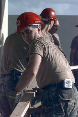 STAFF Sergeant Tim Snyder, Structural Journeyman, 201st Red Horse Air National Guard, Rickenbacker Air National Guard Base, Columbus, Ohio, moves boards that will be used to convert old dorms at Andersen Air Force Base, Guam, into temporary housing for victims of Typhoon Paka