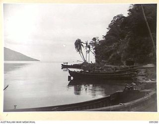 RABAUL, NEW BRITAIN, 1945-12-01. JAPANESE BARGES AND TUNNELS ON THE FORESHORE OF KARAVIA BAY. THE TUNNELS, WERE DUG BY THE JAPANESE AS A PROTECTION AGAINST ALLIED AIR ATTACK