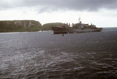 A port bow view of the combat stores ship USS NIAGARA FALLS (AFS 3) entering port under gray skies