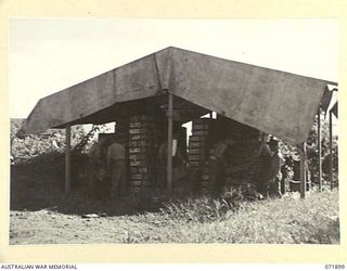 LAE, NEW GUINEA. 1944-03-30. MEMBERS OF THE 103RD FIELD AMMUNITION DEPOT AT A FIELD STACK OF SMALL ARMS AMMUNITION IN THE BEACH TRANSIT DUMP