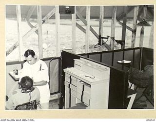 LAE, NEW GUINEA. 1944-11-09. NX102479 CAPTAIN R.W. HALLIDAY, DENTAL OFFICER, 112TH CONVALESCENT DEPOT, WORKING IN THE UNIT SURGERY