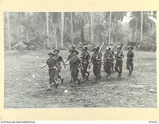 SIAR, NEW GUINEA. 1944-06-23. PERSONNEL OF COMPANY HEADQUARTERS OF D COMPANY, 57/60TH INFANTRY BATTALION MOVING OFF THE UNIT PARADE GROUND AT THE CONCLUSION OF THE MORNING PARADE. IDENTIFIED ..