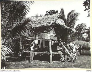 1943-09-20. NEW GUINEA. BUSO RIVER - LAE AREA. AT ALUKIE VILLAGE AUSTRALIANS HANG UP THEIR WASHING OUTSIDE A NATIVE HUT. (NEGATIVE BY H. DICK)