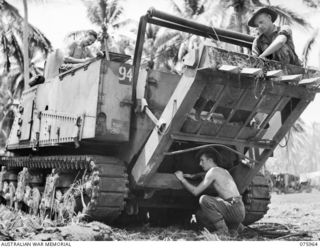 MILILAT, NEW GUINEA. 1944-09-12. PERSONNEL OF THE AUSTRALIAN ELECTRICAL AND MECHANICAL ENGINEERS, 2/4TH ARMOURED REGIMENT WORKSHOPS WORKING ON A RECOVERY TANK WHICH THEY HAVE BUILT ON A GENERAL ..