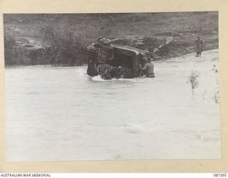 HERBERTON, QLD. 1945-03-03. HEADQUARTERS 9 DIVISION TROOPS LEAVING A TRUCK IN MID-STREAM. THE MEN, COMPETITORS FOR THE GENERAL OFFICER COMMANDING 9 DIVISION GOLD MEDAL FOR RIFLE SHOOTING, ATTEMPTED ..