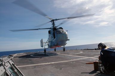 A Russian Federation Navy KA-27 Helix helicopter takes off from the flight pad aboard the USN Ticonderoga Class Guided Missile Cruiser (Aegis), USS COWPENS (CG 63) during a joint Russian Federation Navy-US Navy (USN) humanitarian assistance and disaster relief exercise conducted in the waters near the US Territory of Guam