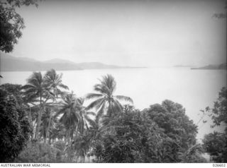 MILNE BAY, PAPUA. 1942-09. VIEW OF MILNE BAY WHERE THE JAPANESE LANDED FROM BARGES. THE THICKLY JUNGLE-CLAD MOUNTAINS RISE UP STEEPLY FROM THE SEA