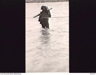 UMI RIVER, NEW GUINEA. 1943-09-29. SX3032 SERGEANT C. F. EDWARDS, "D" COMPANY, 2/27TH AUSTRALIAN INFANTRY BATTALION, CROSSING THE RIVER WITH THE AID OF A ROPE