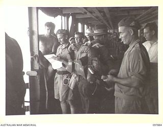 OFF BORAM BEACH, NEW GUINEA. 1945-10-13. THE FIRST BATCH OF TROOPS TO LEAVE THE WEWAK AREA UNDER THE PRIORITY DEMOBILISATION SCHEME WERE MEMBERS OF 6 DIVISION. SHOWN, WARRANT OFFICER 1 G.R. HOGG, 3 ..