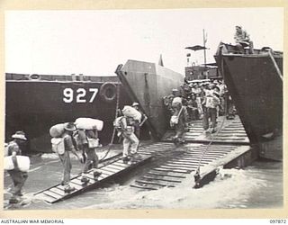 BORAM BEACH, NEW GUINEA. 1945-10-13. THE FIRST BATCH OF TROOPS TO LEAVE THE WEWAK AREA UNDER THE PRIORITY DEMOBILISATION SCHEME WERE MEMBERS OF 6 DIVISION. SHOWN, TROOPS MOVING ONTO THE LANDING ..