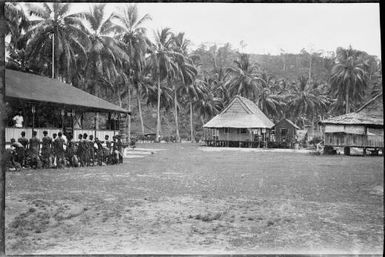 Group of people being addressed from a verandah with other buildings in the middle distance, New Guinea, ca. 1929 / Sarah Chinnery