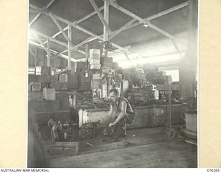 LAE, NEW GUINEA. 1944-09-27. A FITTER CHECKING A SMALL LATHE MOTOR IN THE WORKSHOPS OF THE 43RD FIELD ORDNANCE DEPOT