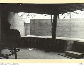 PORT MORESBY, PAPUA, NEW GUINEA. 1944-03-27. NO 1 GUN EMPLACEMENT PAGA BATTERY, COAST ARTILLERY VIEWED FROM THE LEFT OF THE GUN FLOOR AND SHOWING THE REINFORCED CONCRETE BLAST WALL AND ENTRANCE